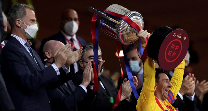 epa09142346 FC Barcelona's striker Lionel Messi (R) receives from Spain's King Felipe VI (L) the champions trophy following the Spanish King's Cup 2021 final soccer match between FC Barcelona and Athletic Bilbao held at La Cartuja Stadium, in Seville, southern Spain, 17 April 2021.  EPA-EFE/Julio Munoz