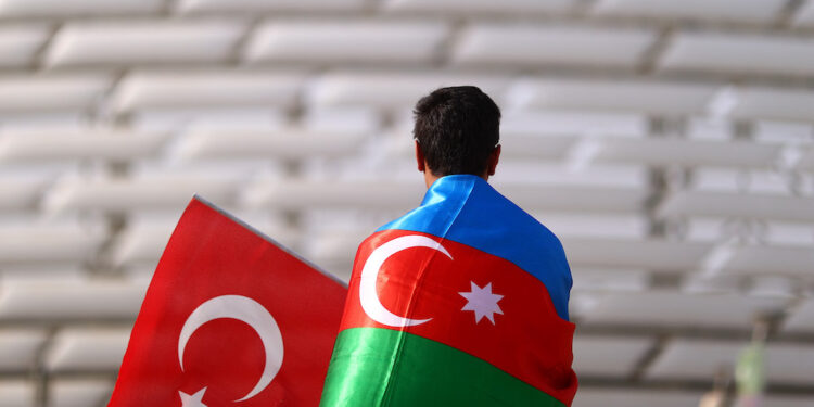 BAKU, AZERBAIJAN - JUNE 20: A Turkey fan wearing a Azerbaijan flag looks on outside the stadium prior to the UEFA Euro 2020 Championship Group A match between Switzerland and Turkey at Baku Olimpiya Stadionu on June 20, 2021 in Baku, Azerbaijan. (Photo by Francois Nel - UEFA/UEFA via Getty Images)