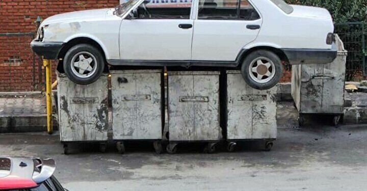 BASAKSEHIR'DE BIR SANAYI SITESINDEKI IS YERLERININ ONUNU KAPATAN OTOMOBILIN SAHIBINE ULASAMAYAN ESNAF, FORKLIFT ILE KALDIRDIKLARI ARACI COP KONTEYNERLERININ UZERINE BIRAKTI. FOTO: ERSAN SAN -ISTANBUL-DHA