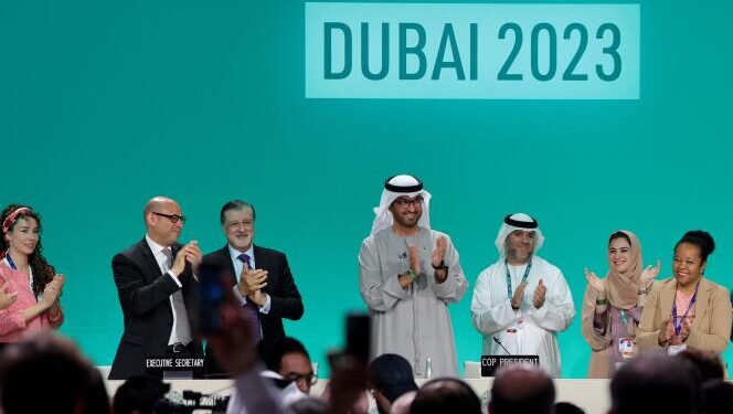 COP28 president Sultan Ahmed Al Jaber (C) applauds among other officials before a plenary session during the United Nations climate summit in Dubai on December 13, 2023. Nations adopted the first ever UN climate deal that calls for the world to transition away from fossil fuels. "We have the basis to make transformational change happen," COP28 president Sultan Al Jaber said at the UN climate summit in Dubai before the deal was adopted by consensus, prompting delegates to rise and applaud.
 (Photo by Giuseppe CACACE / AFP)